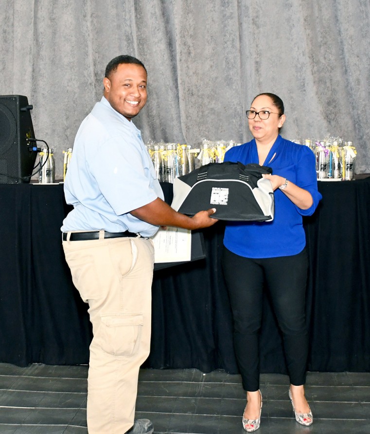 Mr. Daniel Dawkins receives diploma from Ms Leyda Nicholson-Makasare for successfully completing his 18-month Level III Diploma in General Construction
