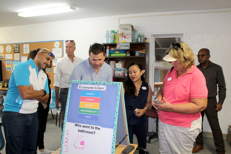 Board Members from left Faramarz Romer, David Watler Y Chairman and Sara Mackay listen as Y staff member Jinky shows some of the Brac afterschool programme elements