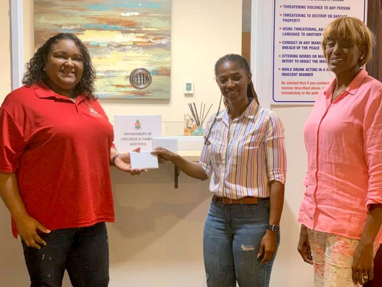 Before the curfews were imposed, the OAG raised funds and Katrina Thomas (centre) and Gay Frye (right) are pictured handing over a series of vouchers to Acting Director of DCSF, Nicole Carter (left) for distributing to families with children in most need