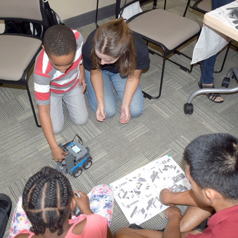 The kids love building the robots, alongside adult volunteers who help them