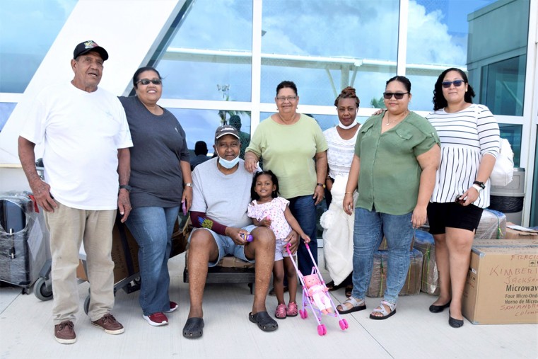 Outside ORIA, a small group of Cayman’s Columbian community stand alongside the goods they have brought, waiting for the plane to land