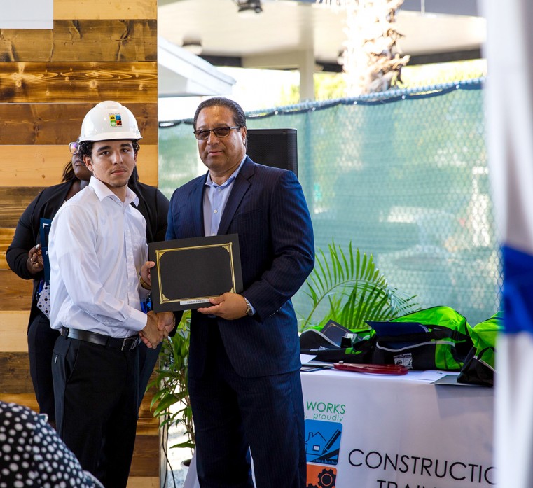 Premier Hon. Alden McLaughlin presenting Erwin Swaby with the 2019-2020 Apprentice of the Year certificate