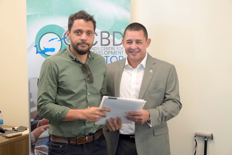 Badir Awe managing director Awesome Productions, receives his starter pack from Minister Hew