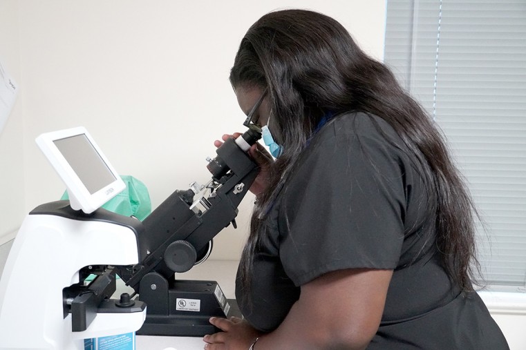 Eye Clinic Intern Kimberly Sterling using equipment in the Lions Eye Clinic