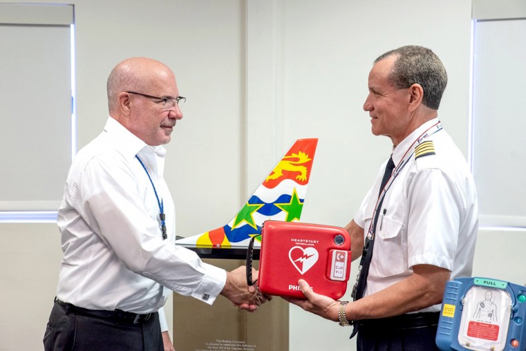 President of the Cayman Airline Pilots’ Association (CAPA), Captain Gary Hydes, (right) presents an Automated External Defibrillator (AED) to Cayman Airways President and CEO, Fabian Whorms. The AED’s