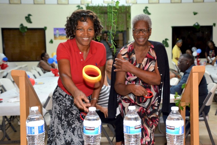 Ms. Carol and Ms. Joanne try to snag a bottle of water in the horseshoe game