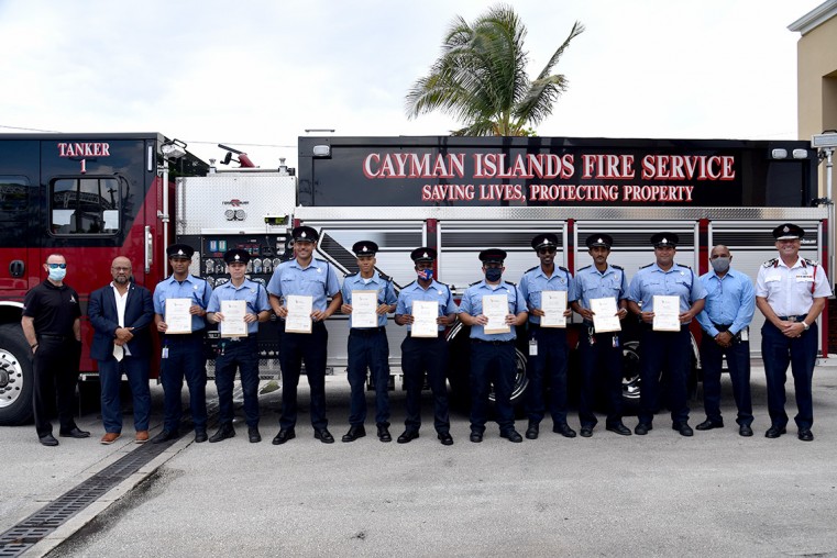 Home Affairs Ministry representatives pose for a group shot with the firefighters who received their IFE qualifications, following thee brief presentation ceremony at Central Fire Station