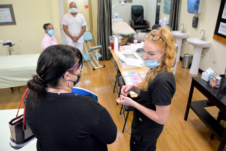 Cayman Career Academy’s Lecturer, Hannah Taylor (right) chats with a prospective student about what the beauty school can offer her