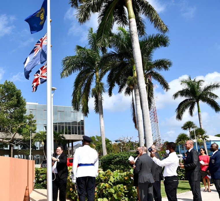 The Premier, Hon. Wayne Panton hoisting the Cayman the Commonwealth flag