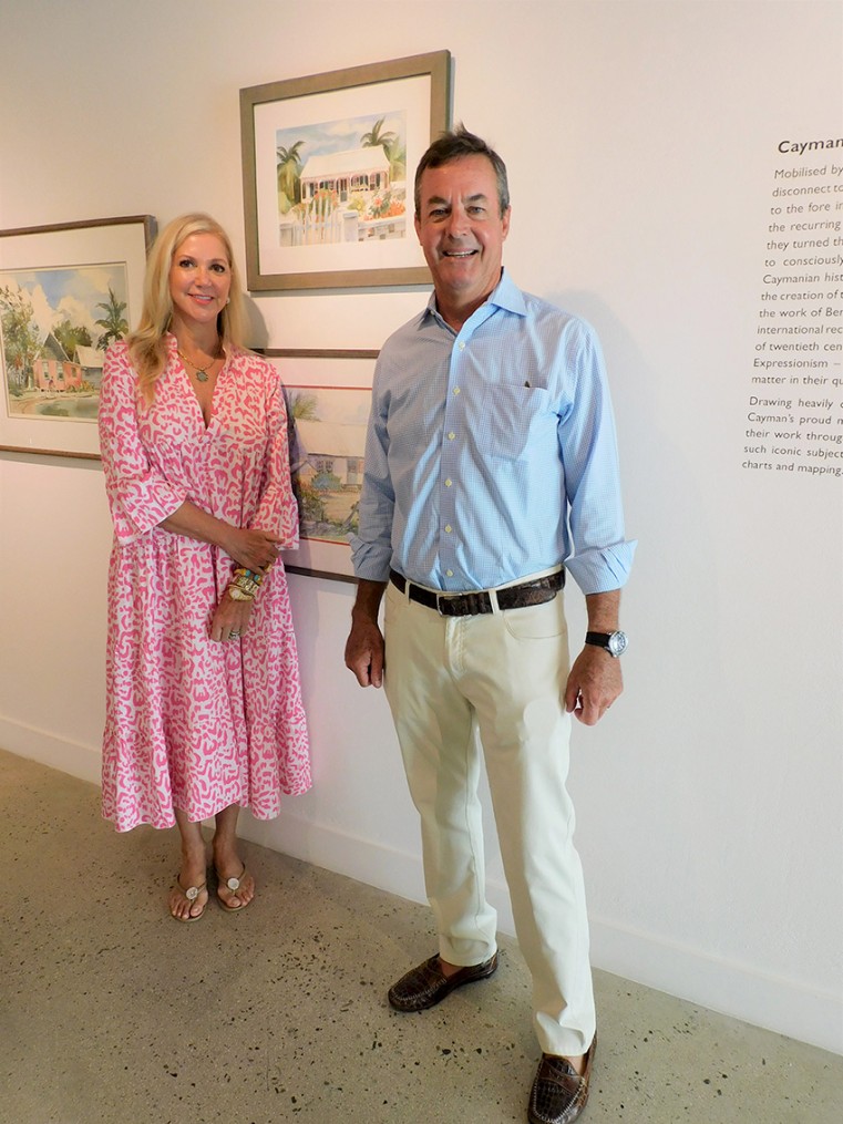 Sarah Louise Wood Ham and husband Scott with Cayman Cottage, the Betty Wood painting that the family is donating to the National Collection.