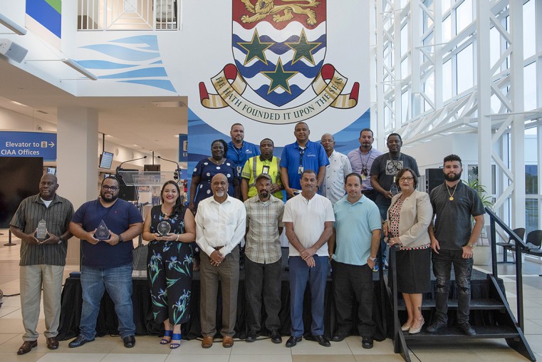 Long-serving employees at Owen Roberts International Airport. Back row (L-R) Vilora Sinclair, William Manderson, Herbert Myles, Armando Ebanks, Edmundo Woods, Timothy (Chad) Yates and Sean Lewinson. F