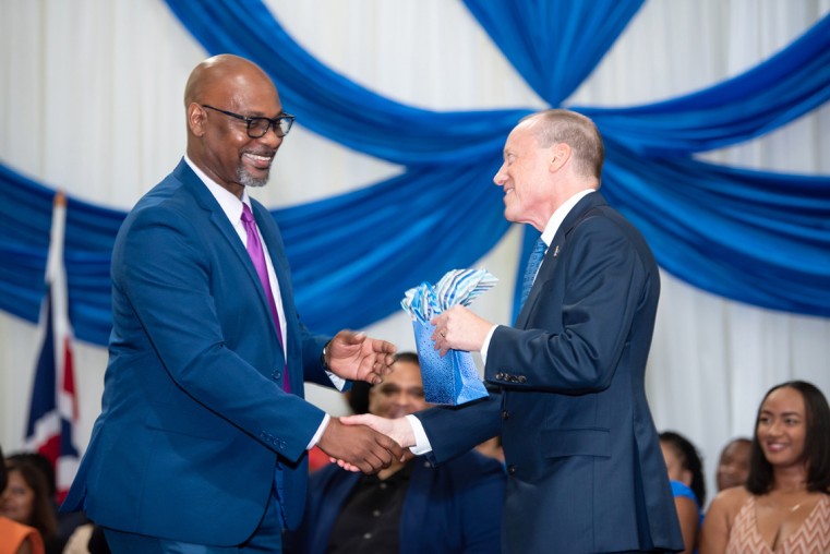 Dr. Richard Wildman (l) presents a token to Governor Martyn Roper (r).