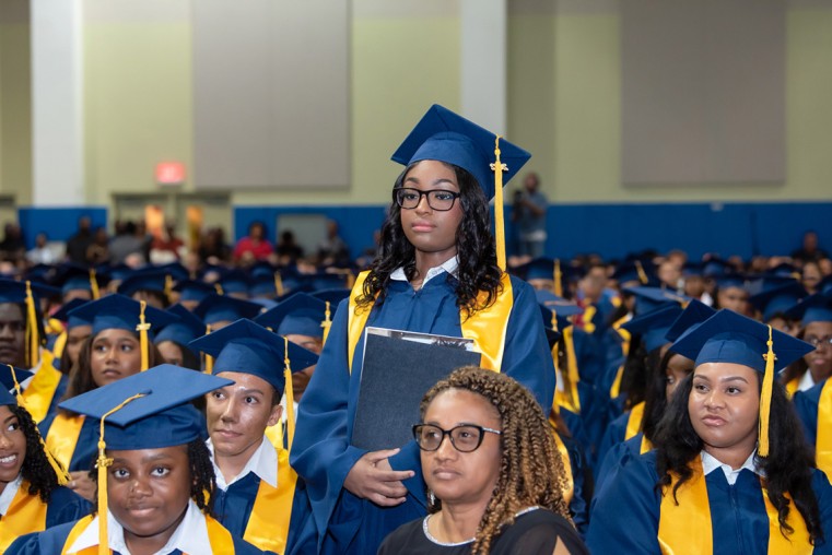 CHHS graduate Jayla Morrison stands briefly during recent the graduation ceremony. She is surrounded by her fellow graduates.