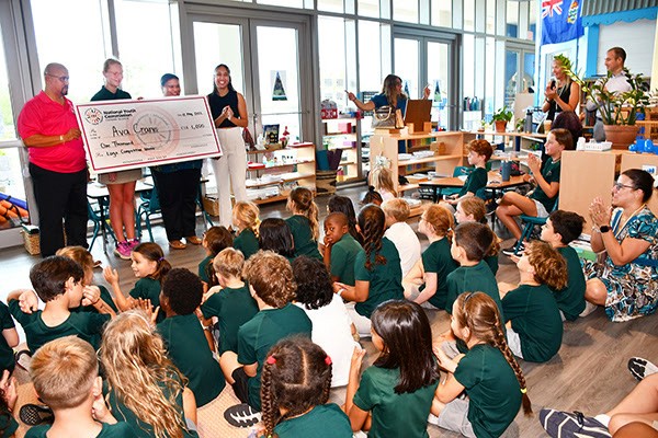 Minister for Youth, Sports, Culture and Heritage, Hon. Bernie Bush presents the $1,000 prize to Ava Crane