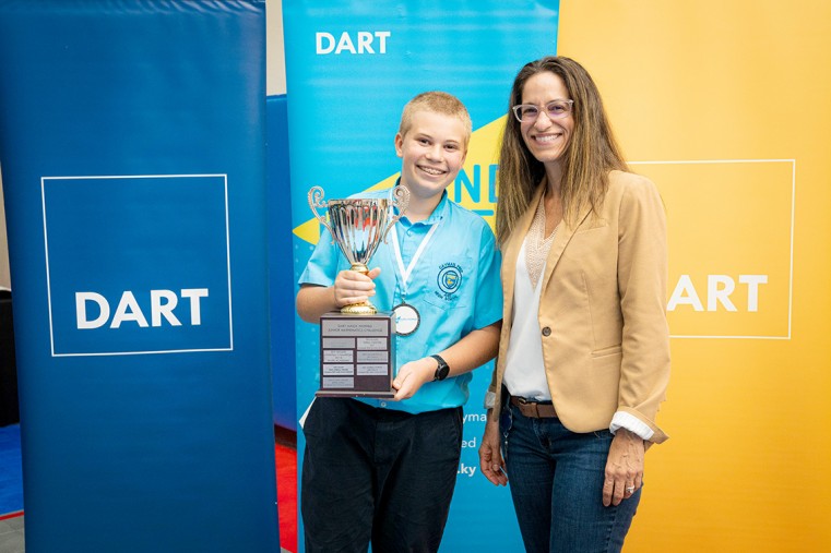 (L-R) Overall Junior challenge winner, Jonty Rogers of Cayman Prep & High School, was presented the winning trophy by Dart Chief of Staff Joanne Lawson.