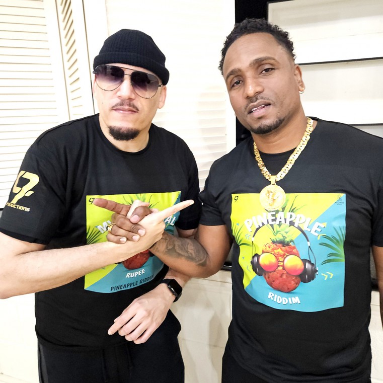Bajan Soca star, Rupert “Rupee” Clarke takes a photo with longtime Trini friend and Road Manager/ Artiste Liaison, Dexter Thomas at the launch of The Pineapple Riddim