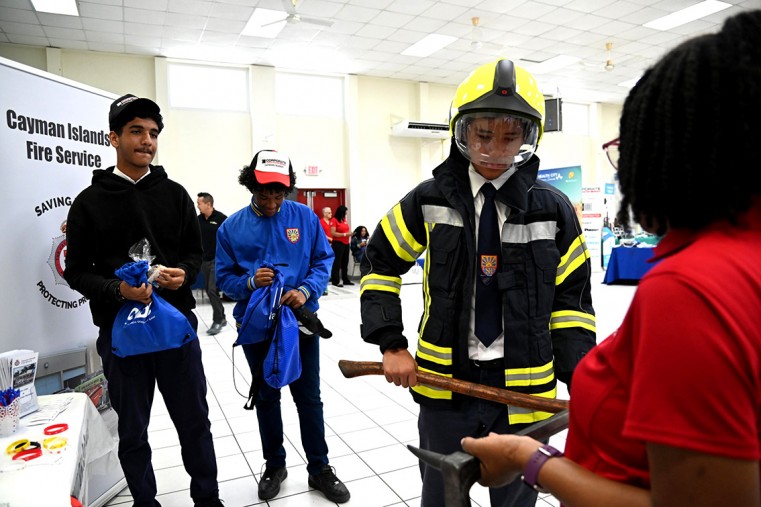 Layman Scott High School students Aryan Champawat, Kai Roberts and Kelwin Scott engage with the Cayman Islands Fire Service Booth