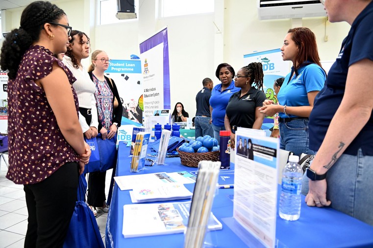 Layman Scott High School Year 12 students Yzara Ebanks, Trihniti Scott and Vera Busby engage with Ministry of Eduaction booth to gain insights into careers in education and Scholarship opportunities.